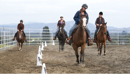 Students riding in outdoor arena