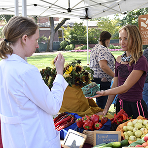 Student selling produce at farm stand
